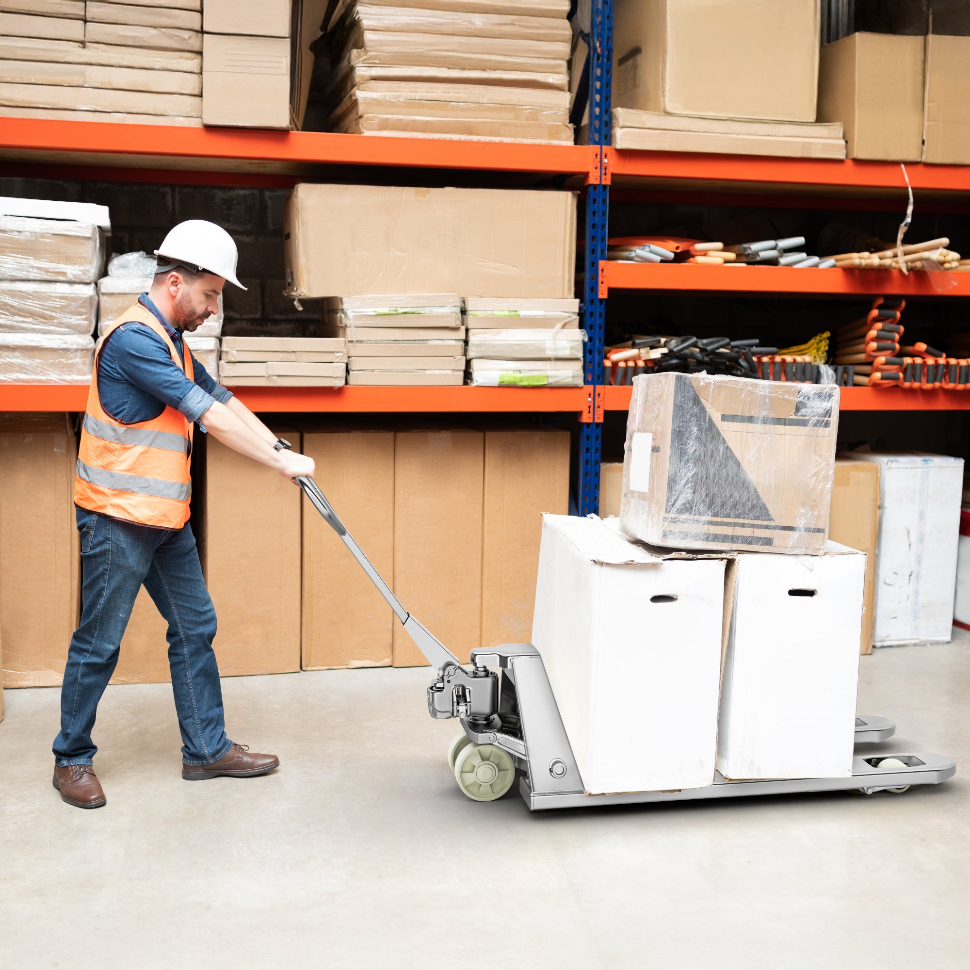 Worker pushing a pallet truck with boxes in a warehouse setting