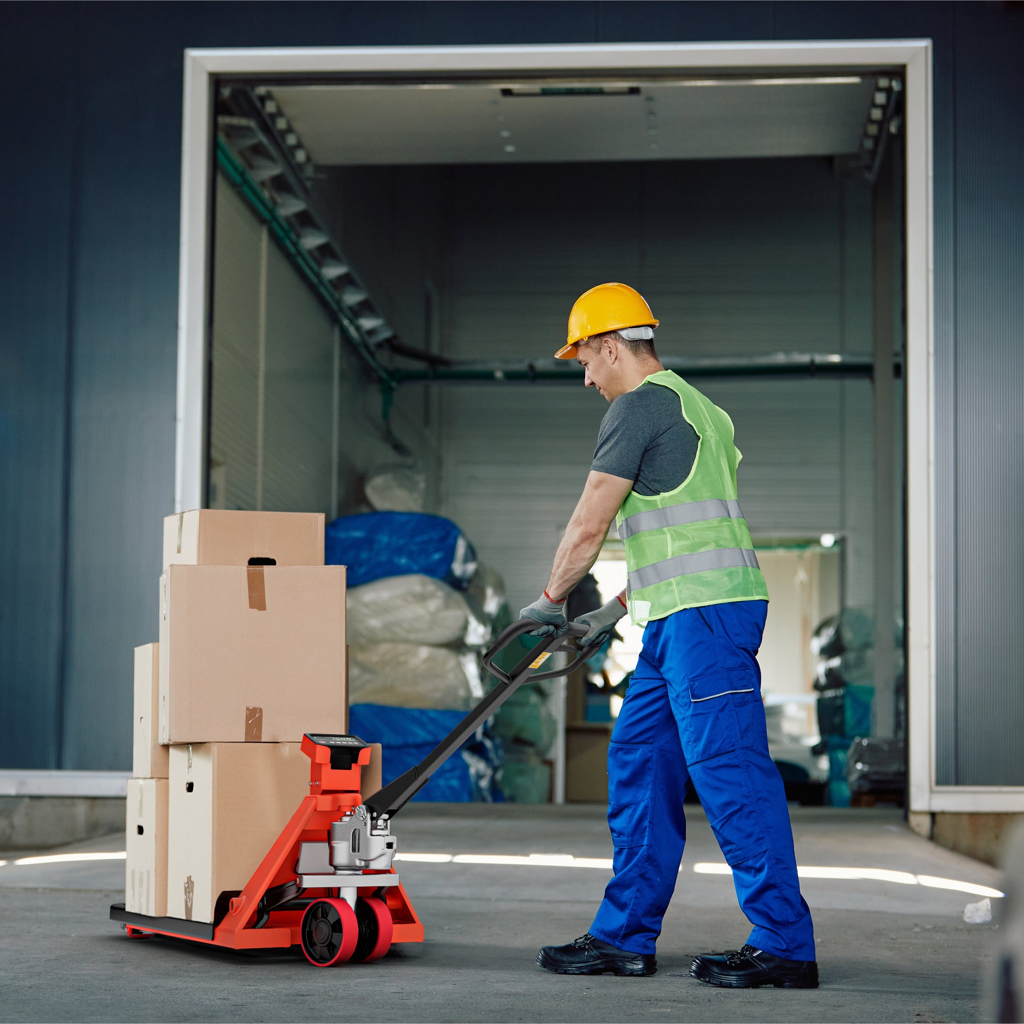 Worker using a pallet jack in a warehouse setting