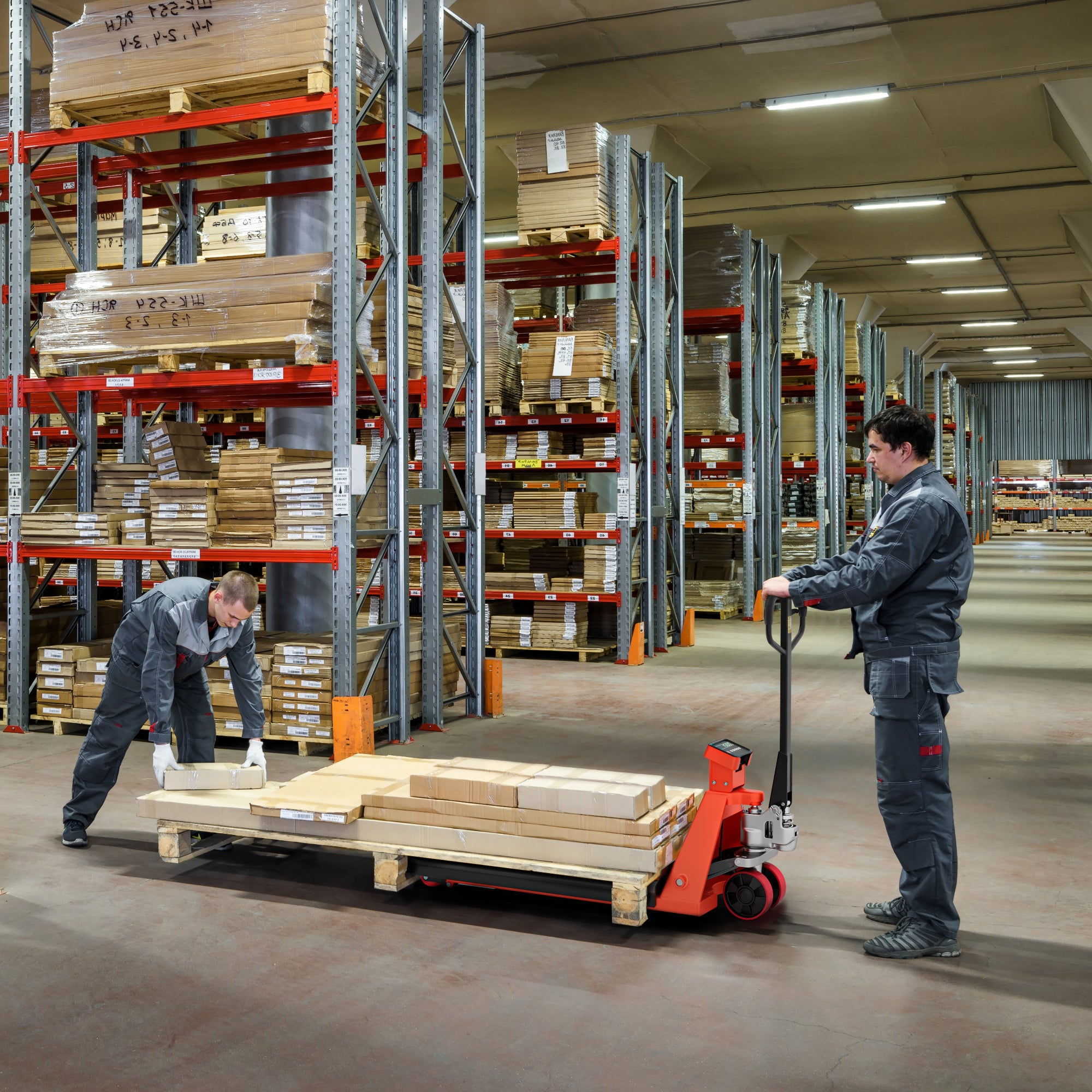 Two workers in a warehouse with pallets and storage racks.