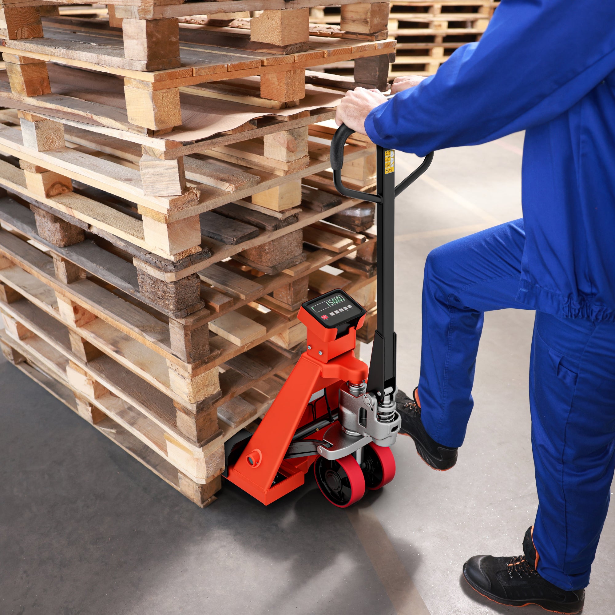 Person using a pallet jack to lift wooden pallets in a warehouse setting