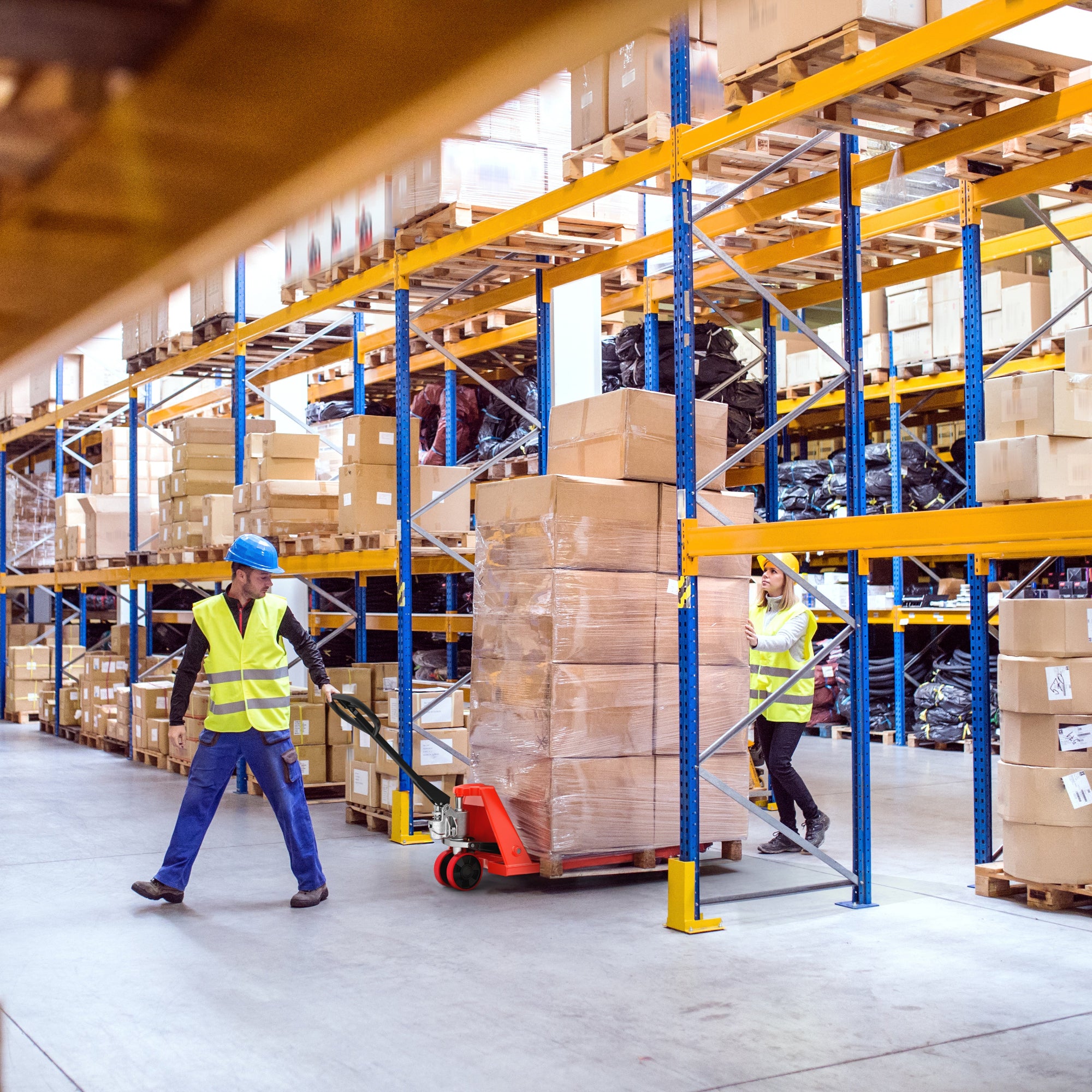 Workers in a warehouse with pallets and boxes